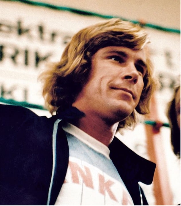 Porträt von James Hunt bei einer Pressekonferenz vor dem Großen Preis von Schweden 1977, mit blonden Haaren und dunkler Jacke