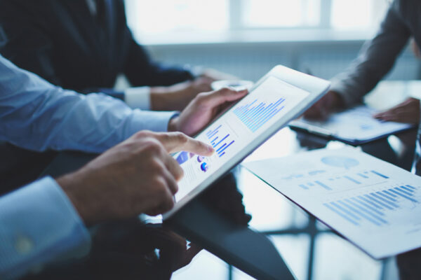 Gestores a analisar gr&aacute;ficos e dados de uma campanha num tablet