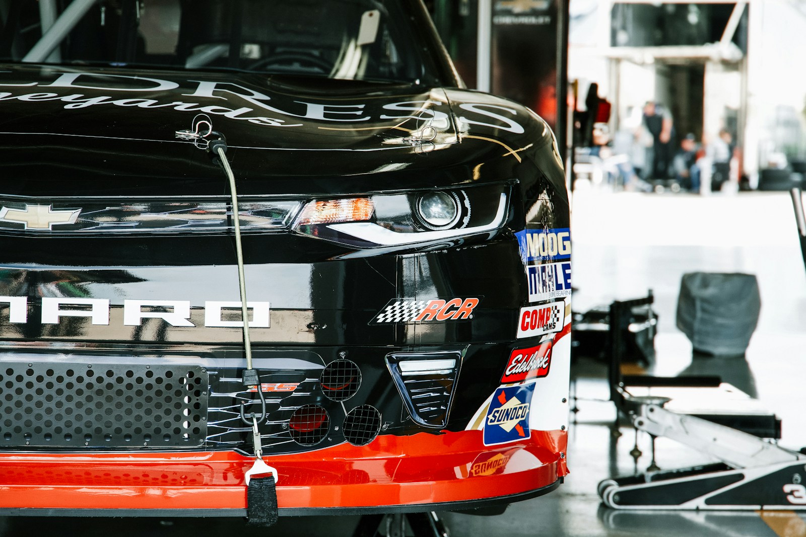 ガレージに置かれたNASCARのシボレー・カマロのフロント、フロントフェンダーに技術サプライヤーのステッカー