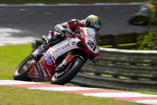 Troy Bayliss 在超級摩托車世界錦標賽中騎著 21 號 Xerox Ducati 壓車過彎